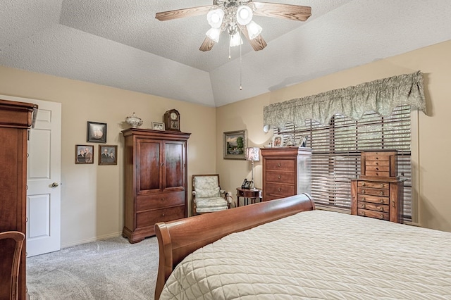 carpeted bedroom with a textured ceiling, a tray ceiling, vaulted ceiling, and ceiling fan