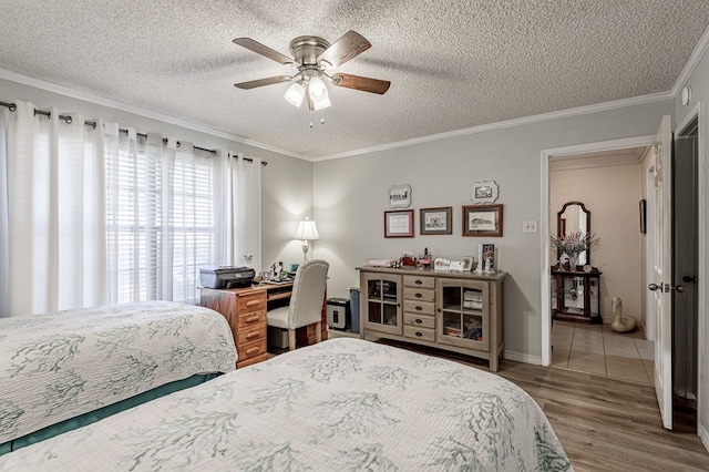 bedroom with ceiling fan, hardwood / wood-style floors, crown molding, and a textured ceiling