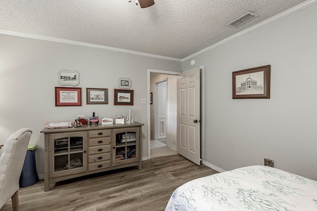 bedroom featuring hardwood / wood-style floors, a textured ceiling, ceiling fan, and crown molding