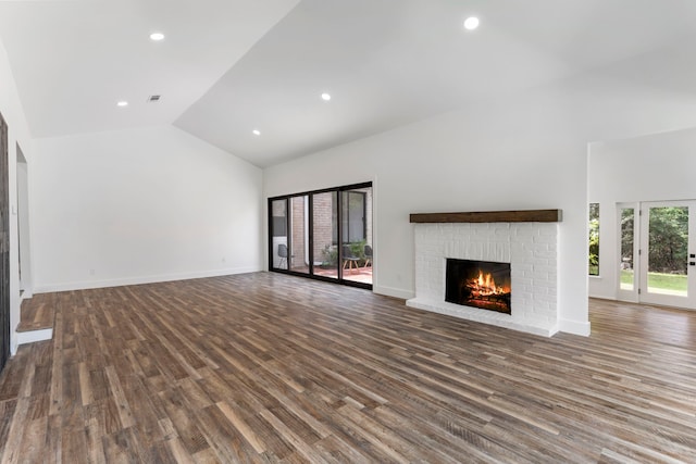 unfurnished living room with dark wood-type flooring, high vaulted ceiling, and a brick fireplace