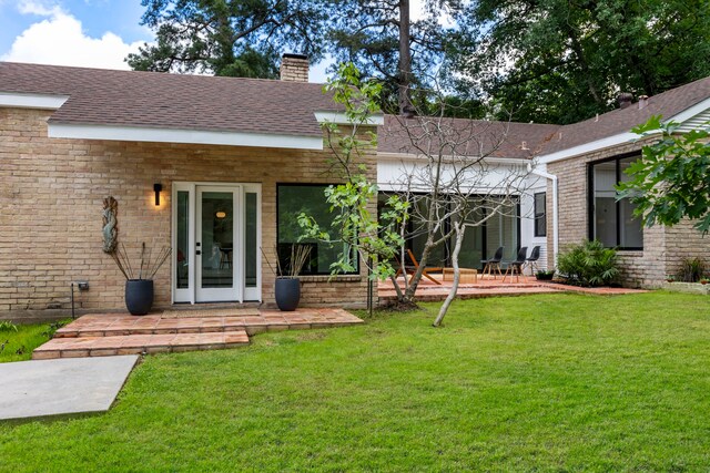 back of property featuring a lawn and a patio area