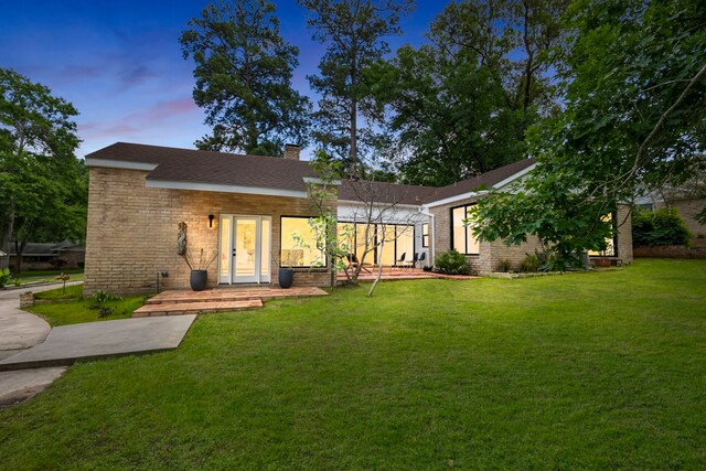 back house at dusk with a yard