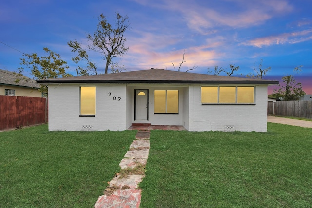 ranch-style home with a yard