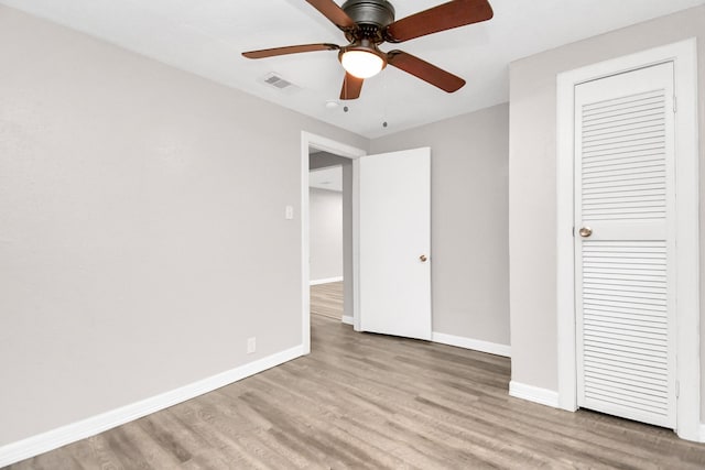 unfurnished bedroom with ceiling fan and light wood-type flooring