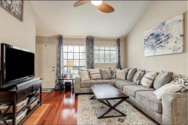 living room featuring ceiling fan, dark wood-type flooring, and vaulted ceiling