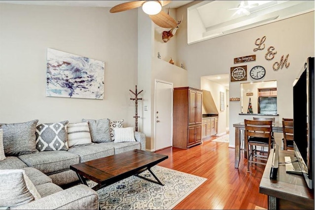 living room featuring beam ceiling, ceiling fan, high vaulted ceiling, and wood-type flooring