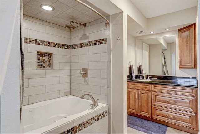 bathroom with tiled shower / bath combo and vanity