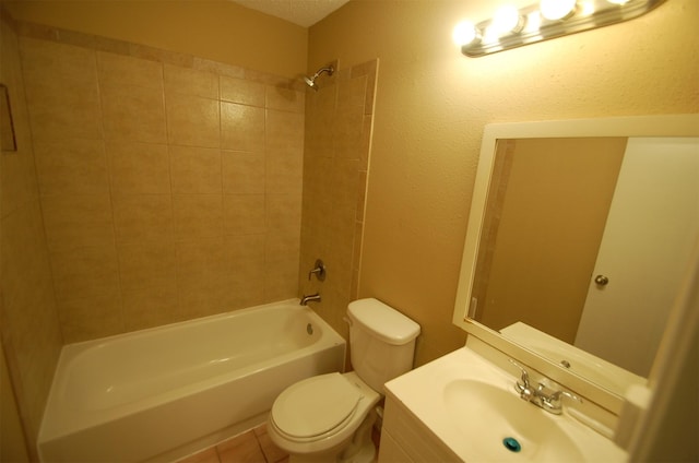 full bathroom with vanity, tiled shower / bath, a textured ceiling, and toilet