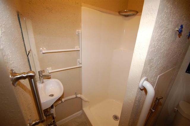 bathroom with sink, toilet, and walk in shower