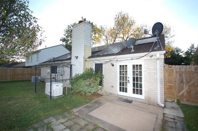 back of house with french doors, cooling unit, a gazebo, a patio, and a lawn