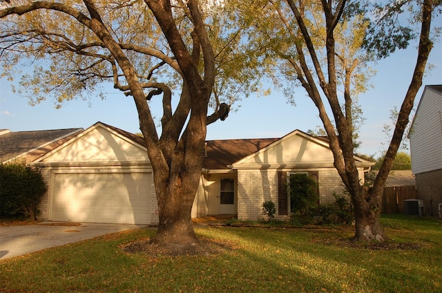 view of front facade featuring a front yard, central AC unit, and a garage