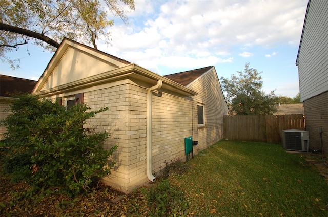 view of property exterior with a yard and central air condition unit