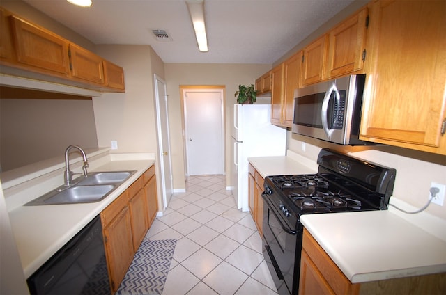 kitchen featuring black appliances, light tile patterned floors, and sink