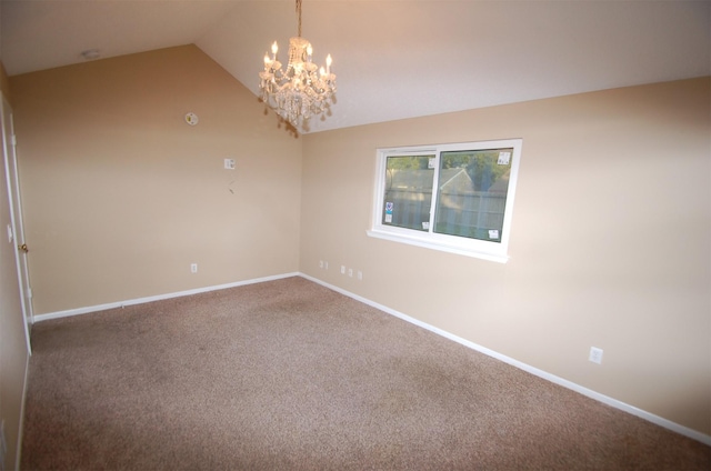 empty room featuring a chandelier, carpet, and vaulted ceiling