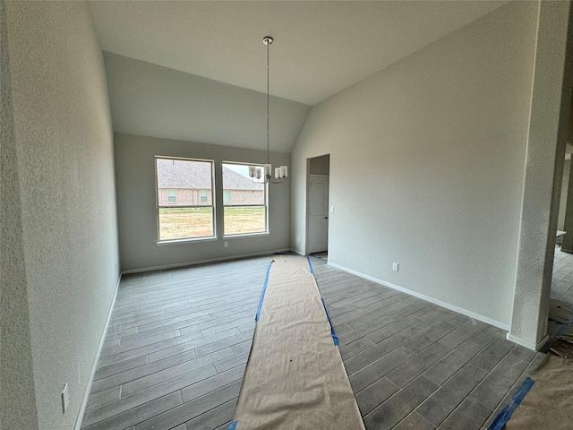 unfurnished dining area with lofted ceiling and an inviting chandelier