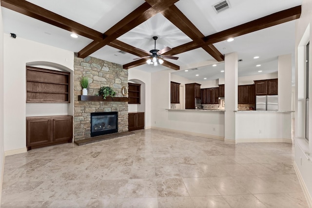 unfurnished living room with ceiling fan, beam ceiling, a fireplace, and coffered ceiling