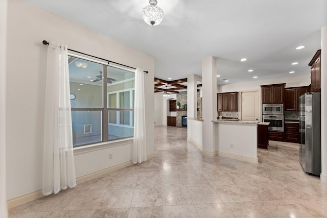 kitchen with a healthy amount of sunlight, a stone fireplace, dark brown cabinetry, and appliances with stainless steel finishes