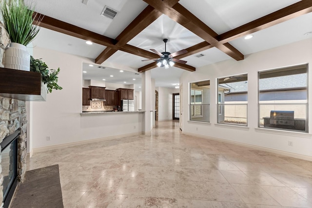 unfurnished living room with beamed ceiling, ceiling fan, a fireplace, and coffered ceiling