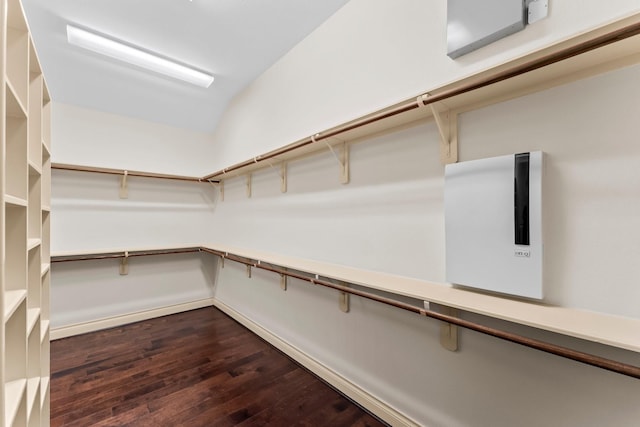 walk in closet with dark hardwood / wood-style floors and vaulted ceiling