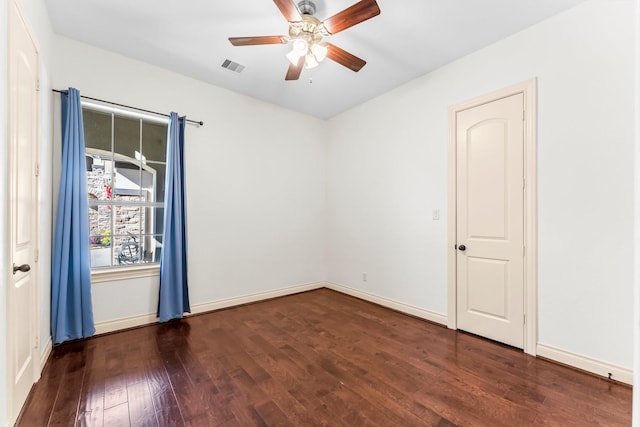 spare room with ceiling fan and dark wood-type flooring