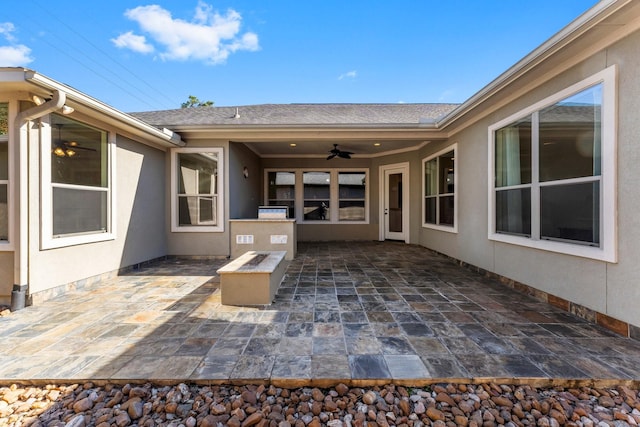 view of patio with ceiling fan and an outdoor fire pit