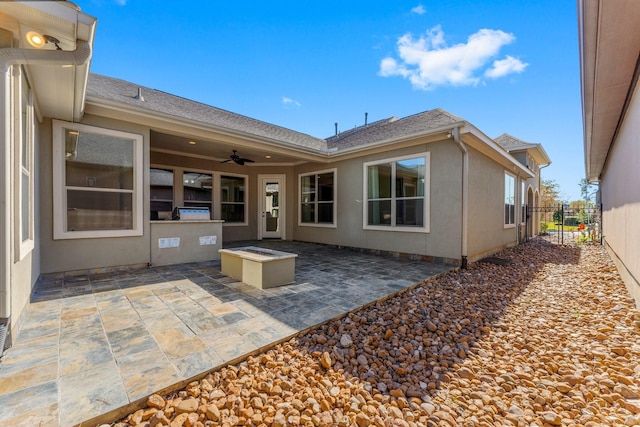 back of property with ceiling fan and a patio area