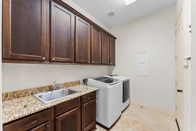 clothes washing area with sink, light tile patterned flooring, cabinets, and independent washer and dryer