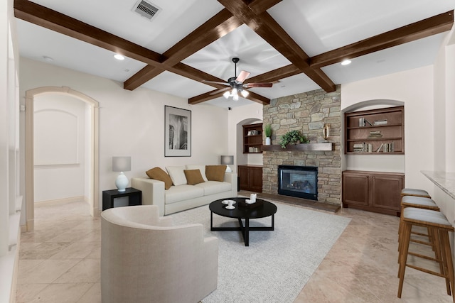 living room featuring beamed ceiling, built in shelves, and coffered ceiling