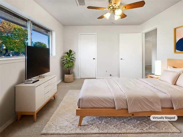 bedroom with ceiling fan and light carpet