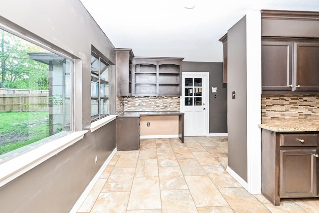 kitchen featuring tasteful backsplash, dark brown cabinets, and a healthy amount of sunlight