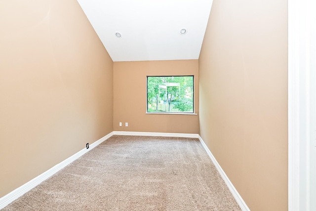 carpeted empty room with lofted ceiling