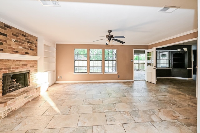 unfurnished living room featuring ceiling fan, built in features, ornamental molding, and a brick fireplace