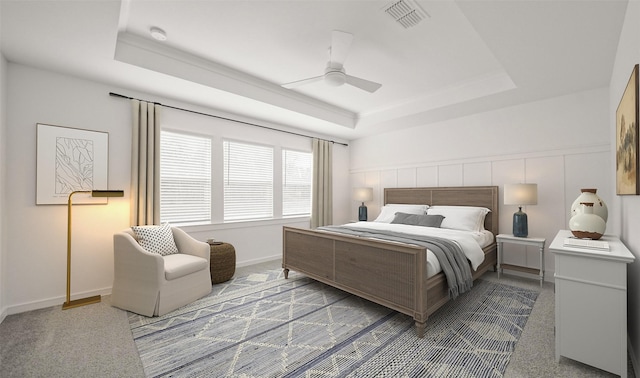 bedroom featuring a tray ceiling, ceiling fan, and carpet