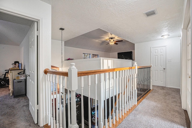 hallway with carpet flooring and a textured ceiling