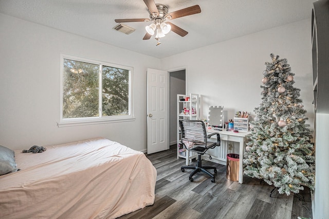 bedroom with ceiling fan, dark wood-type flooring, and a textured ceiling