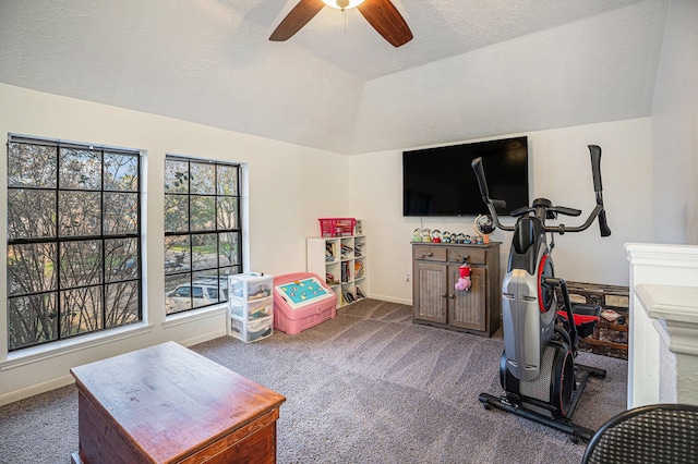 exercise room featuring a textured ceiling, dark carpet, ceiling fan, and lofted ceiling