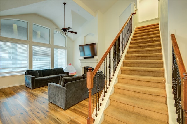 living room with ceiling fan, high vaulted ceiling, and wood-type flooring