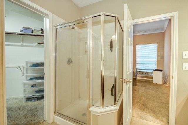 bathroom with crown molding and a shower with door