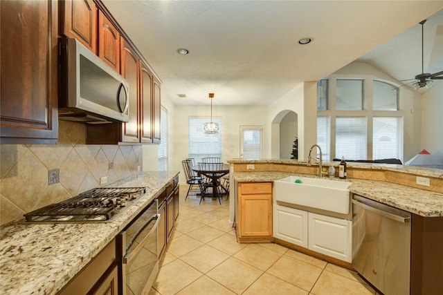 kitchen featuring backsplash, sink, ceiling fan, light tile patterned flooring, and stainless steel appliances