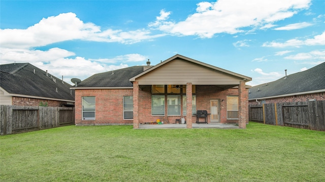 back of house with a patio area and a yard