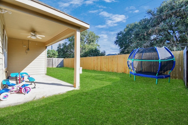 view of yard featuring a patio area, ceiling fan, and a trampoline