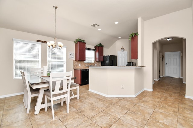 kitchen featuring a wealth of natural light, pendant lighting, black appliances, and lofted ceiling