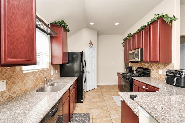 kitchen with light stone countertops, backsplash, sink, black appliances, and lofted ceiling