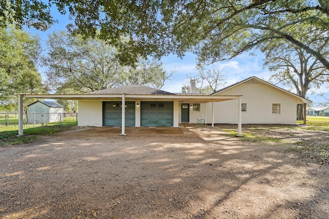 rear view of house featuring a carport and a garage