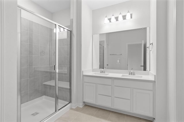 full bath with tile patterned flooring, a sink, and a shower stall