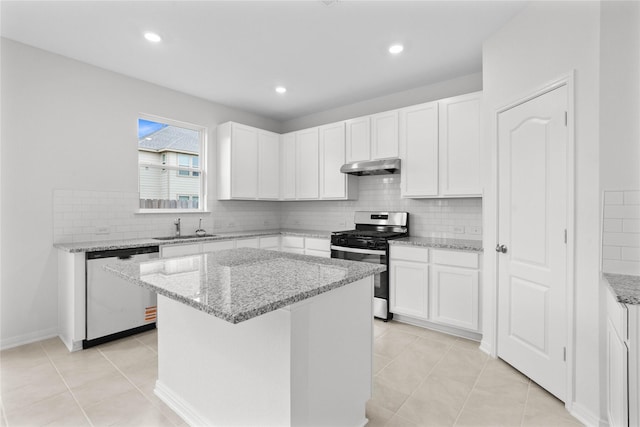 kitchen with light stone counters, a center island, stainless steel appliances, under cabinet range hood, and white cabinetry