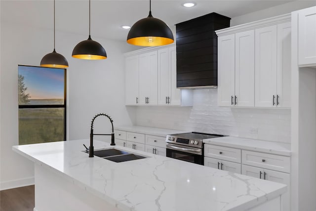 kitchen featuring electric range, decorative light fixtures, white cabinetry, and sink