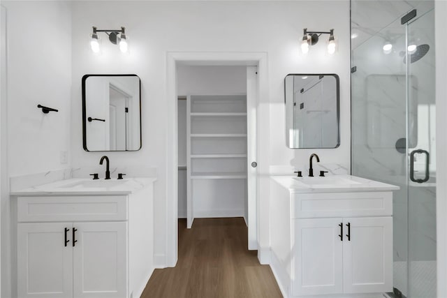 bathroom with hardwood / wood-style flooring, vanity, and a shower with shower door