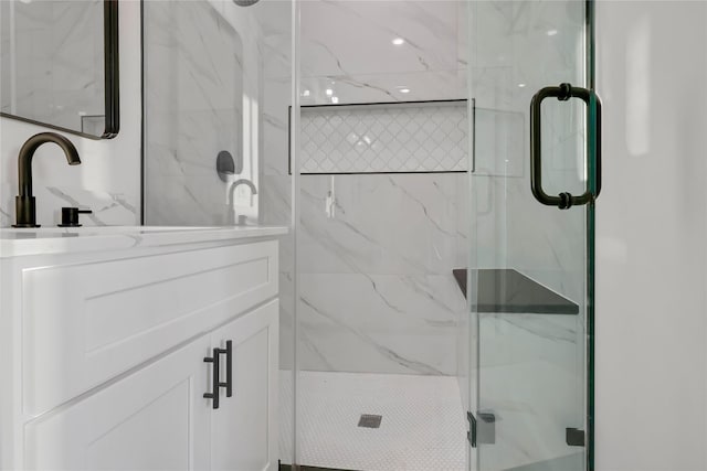 bathroom with a shower with door and sink