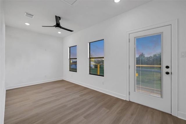 unfurnished room with ceiling fan and light wood-type flooring